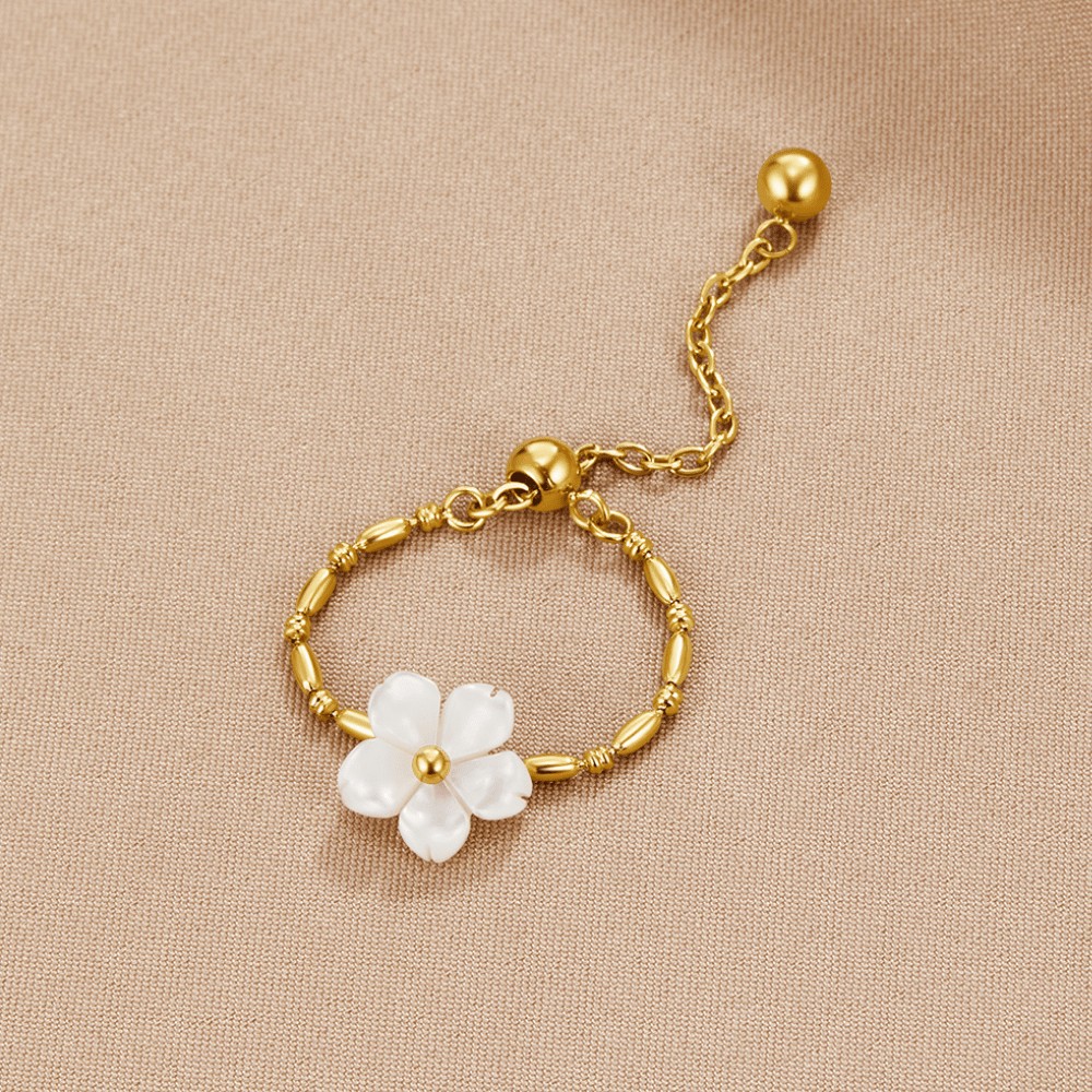 Ring med vit blomma i naturlig snäcka guld