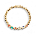 Bracelet à perles dorées et lettres arc-en-ciel