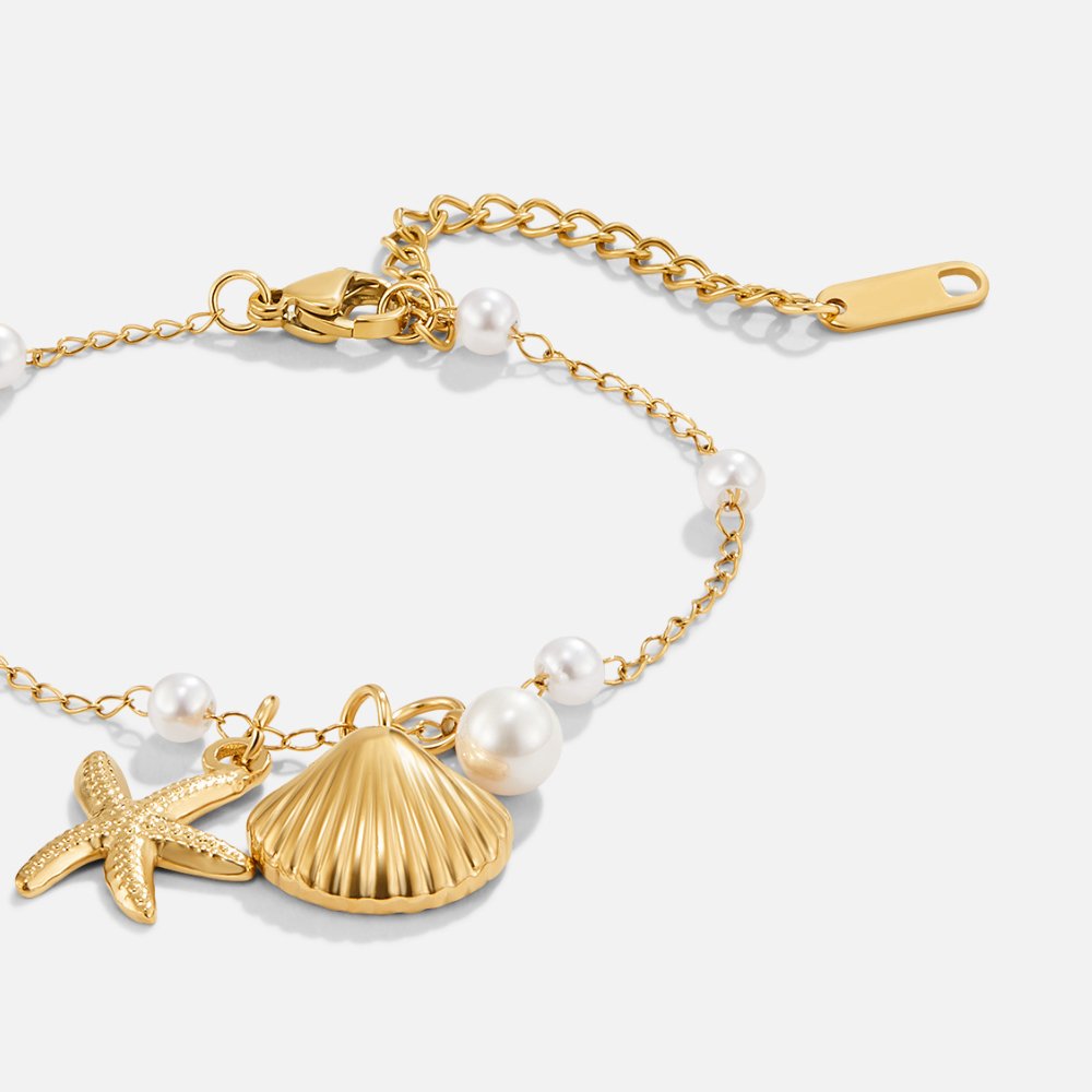 Aria gullfarget armbånd med skjellcharm
