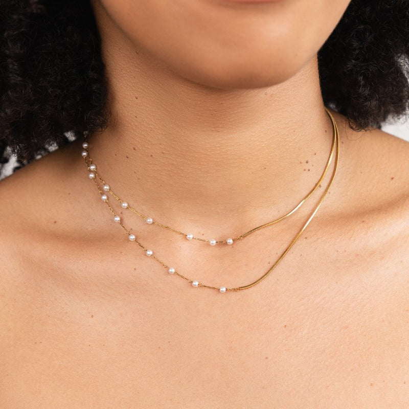 Långt guldfärgat halsband med pärlor och kedja